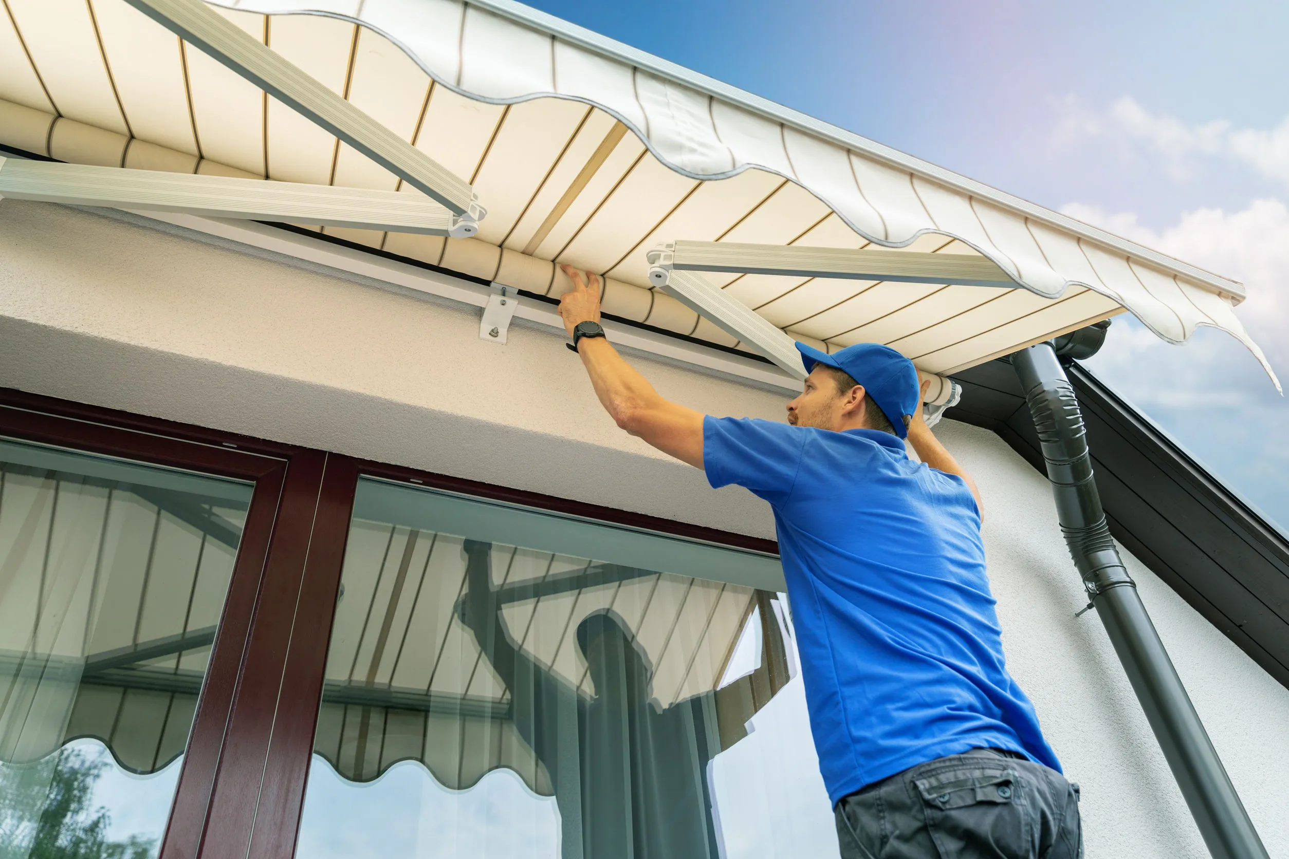 Técnico de Sombratec instalando un toldo retráctil en una fachada