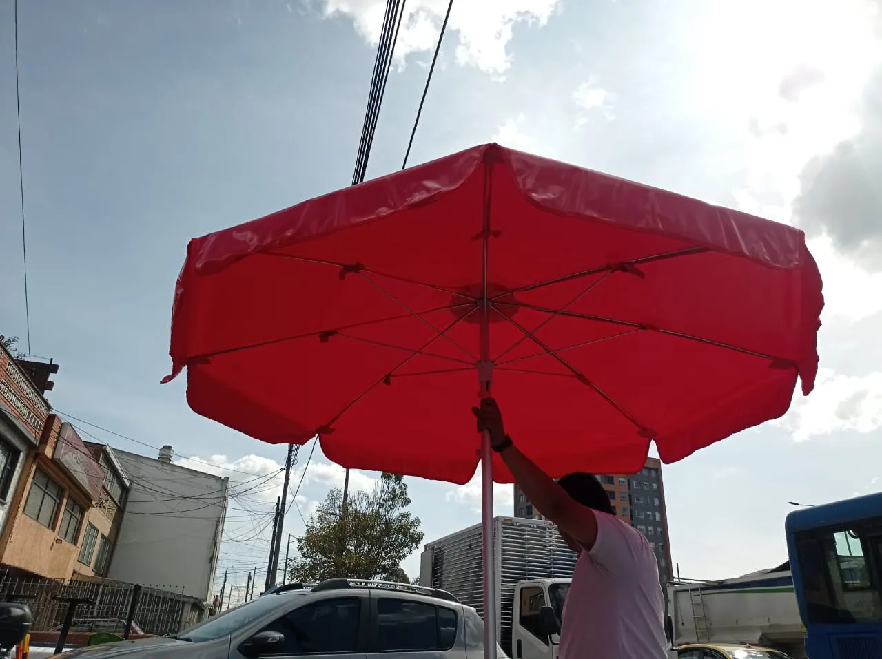 Parasol rojo de ocho paños visto desde abajo mientras se ajusta el mástil