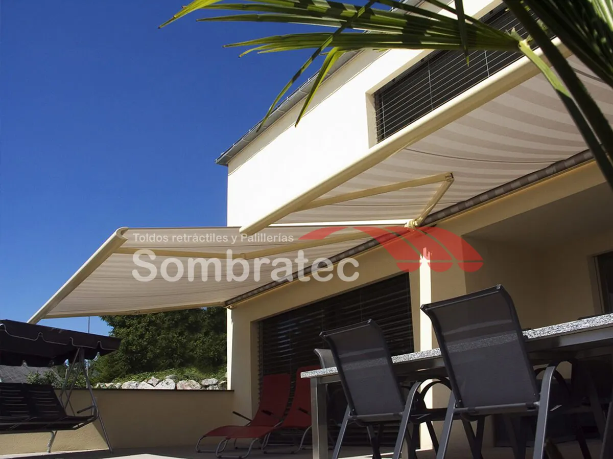 Toldo retráctil beige extendido sobre una terraza con muebles de exterior