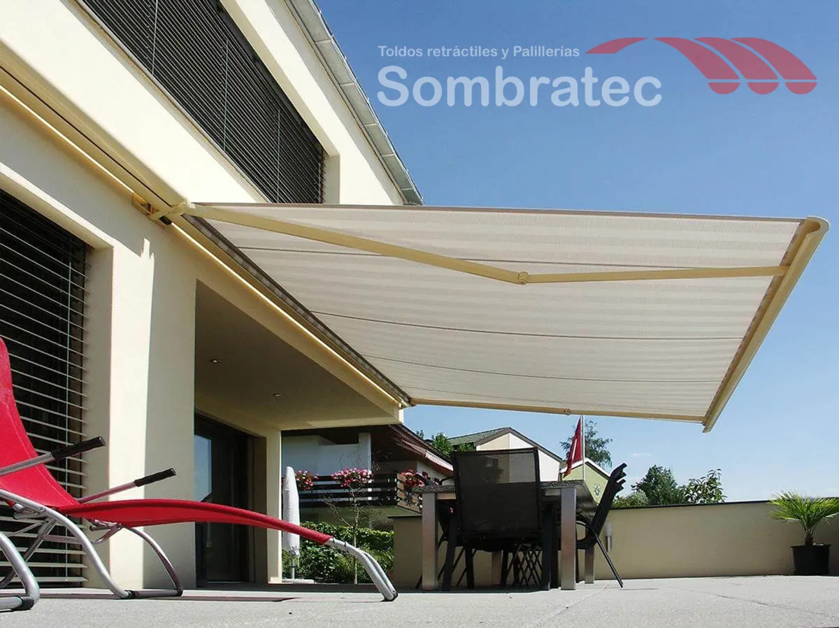 Toldo retráctil de brazos invisibles desplegado sobre la terraza de una vivienda