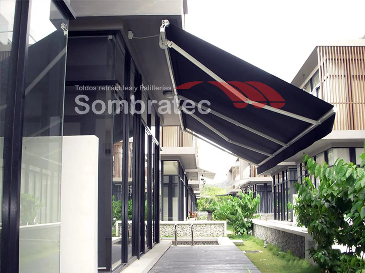 Toldo retráctil azul oscuro instalado en la fachada de un conjunto residencial