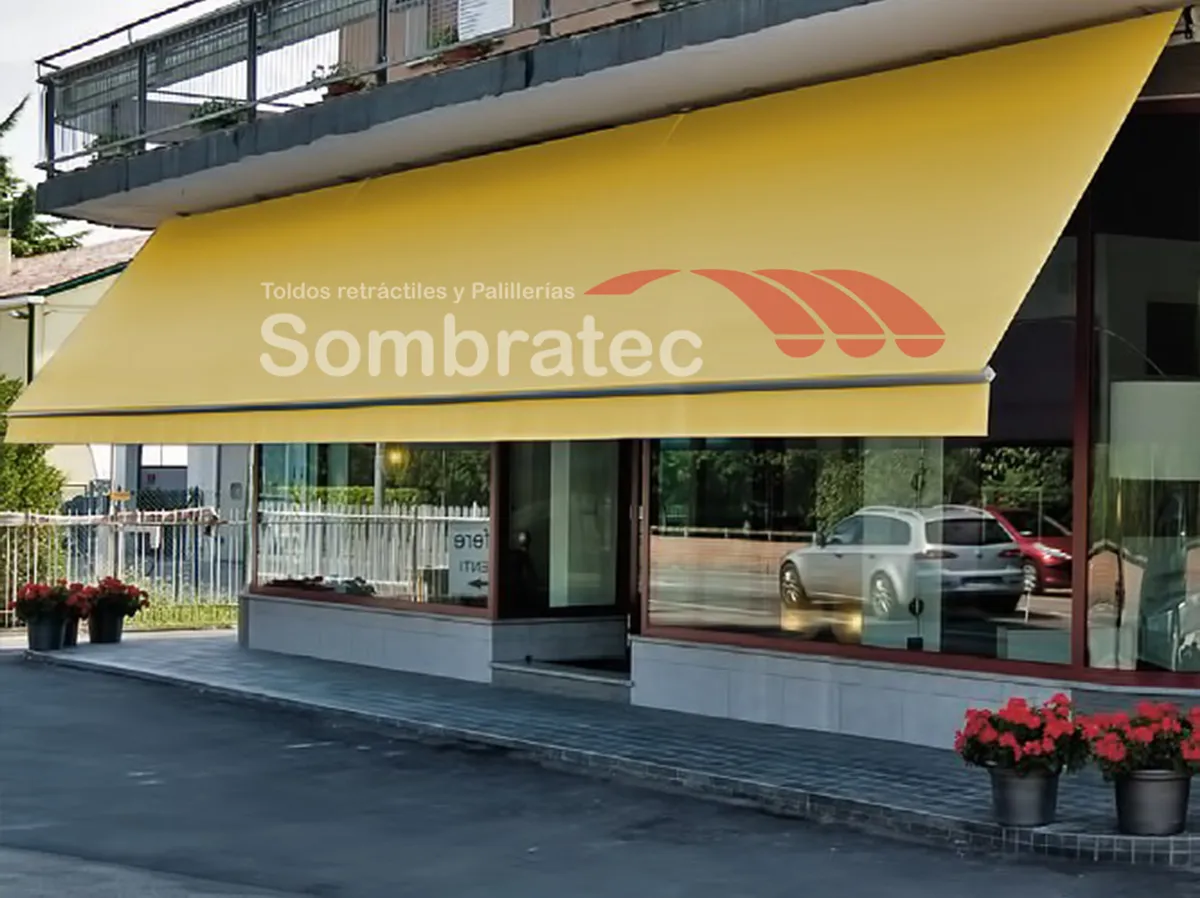Toldo retráctil amarillo sobre la vitrina de un local comercial