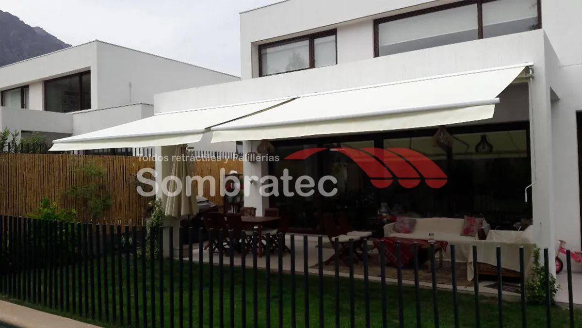 Toldo retráctil beige instalado en una casa moderna de fachada blanca