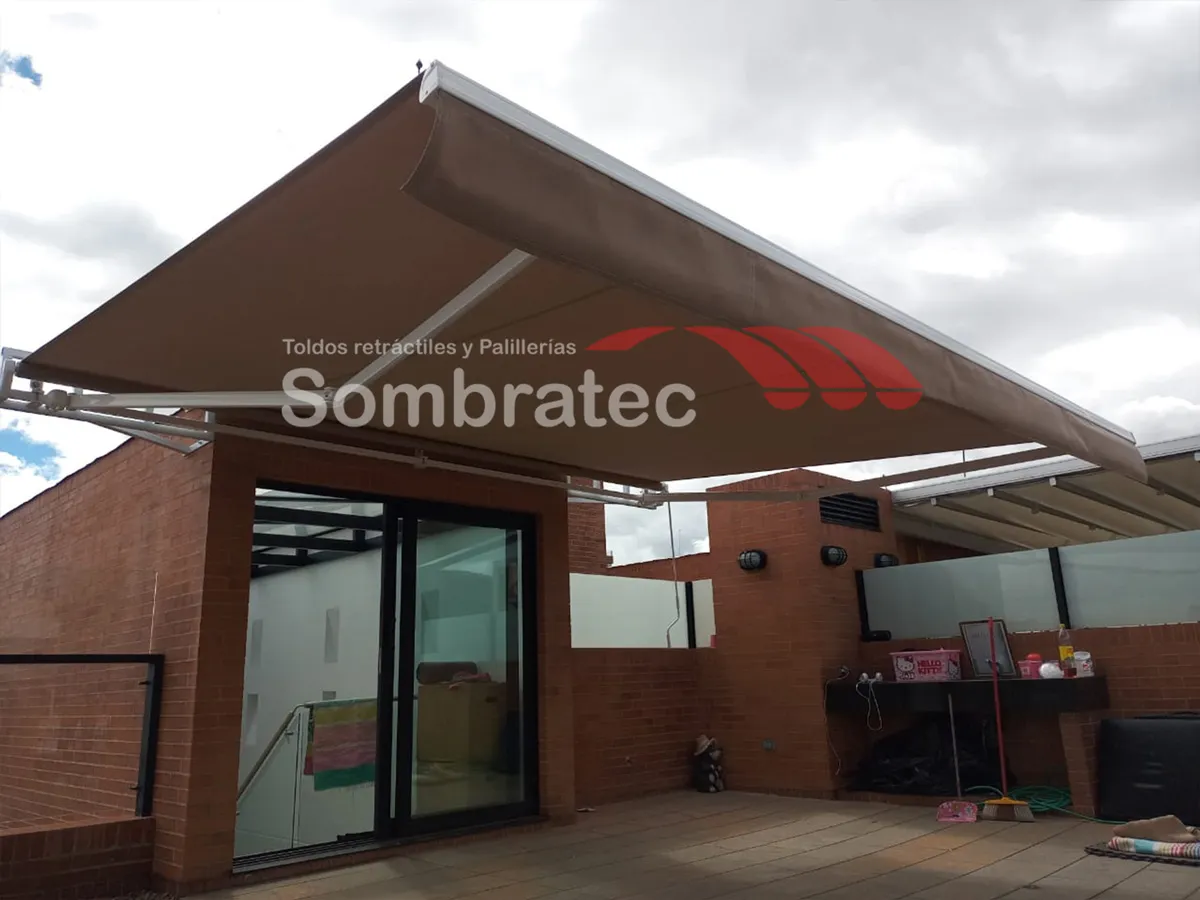 Toldo retráctil instalado sobre la fachada en ladrillo de un local